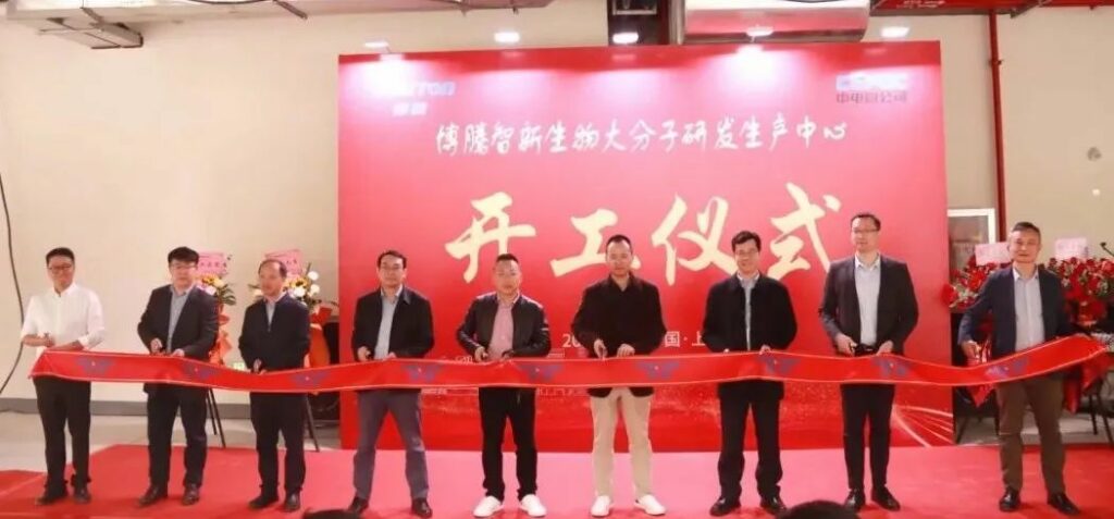 A group of people standing in front of a red ribbon.