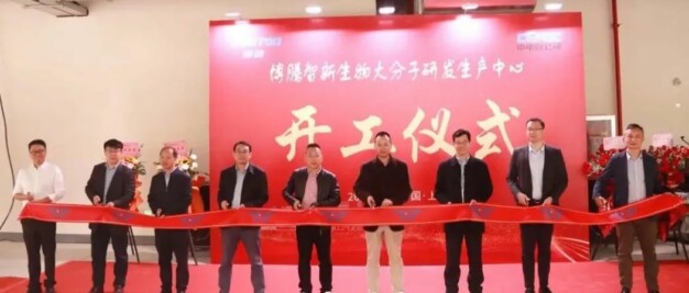 A group of people standing in front of a red ribbon.