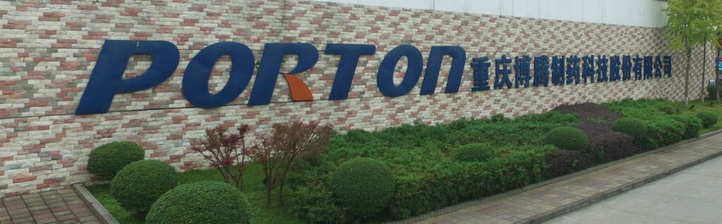 A sign for porton technology in front of a brick building.