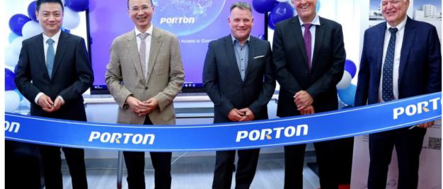 Five men stand behind a ceremonial ribbon labeled "PORTON," with balloons and a screen displaying the same text in the background.