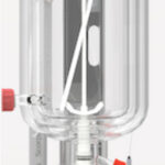 A clear cylindrical laboratory reactor with a digital control interface, featuring multiple ports and red valve connectors.