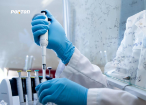 A scientist in blue gloves uses a pipette in a lab focused on pharmaceutical development, with scientific formulas and molecular modeling diagrams adorning the whiteboard in the background.