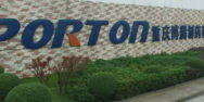 A sign for porton technology in front of a brick building.