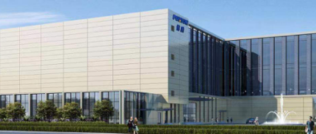 The large modern building at the Porton site boasts glass windows and a fountain in front, set amid lush greenery, showcasing its state-of-the-art construction as a premier drug product GMP facility.