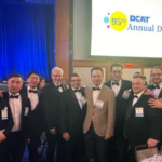 A group of men in tuxedos posing for a picture.