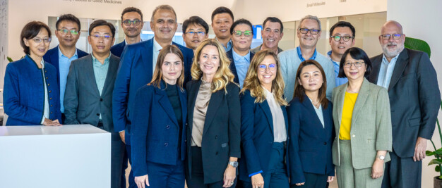 A group of 17 individuals in formal attire poses indoors against a white backdrop, with "PORTON" prominently displayed behind them. This gathering highlights Porton Pharma Solutions' commitment to excellence in the CDMO industry during the CPHI Europe Review.