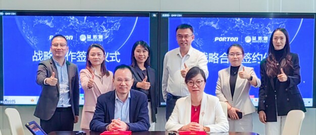 A group of eight people in business attire pose with thumbs up in a conference room, celebrating a strategic partnership. Two are seated at the table, while a screen behind them showcases business logos and text from Porton Pharma Solutions and Shanghai InnoStar.